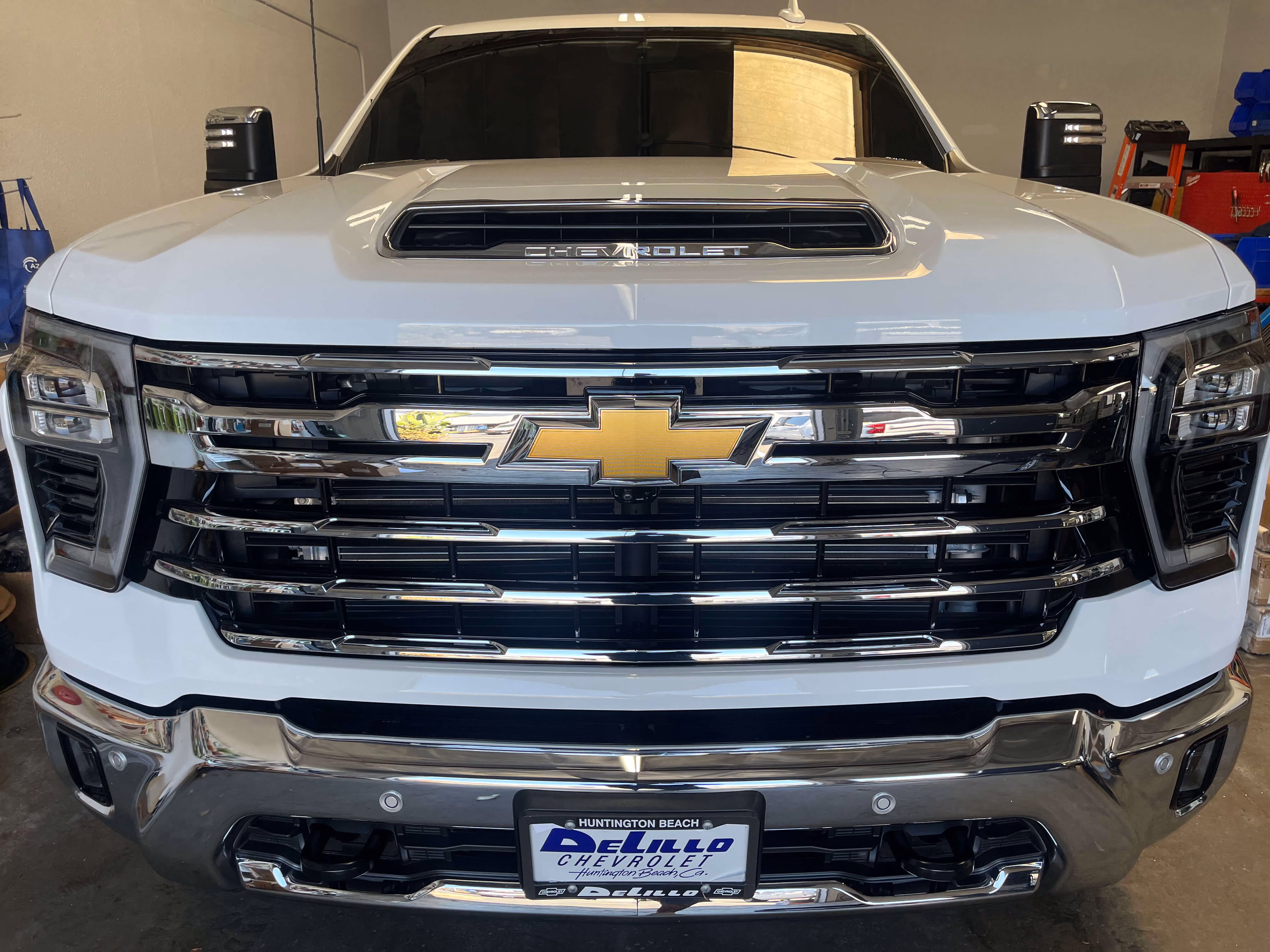 Front view of white Chevrolet truck with chrome grille and DeLillo Chevrolet license plate.
